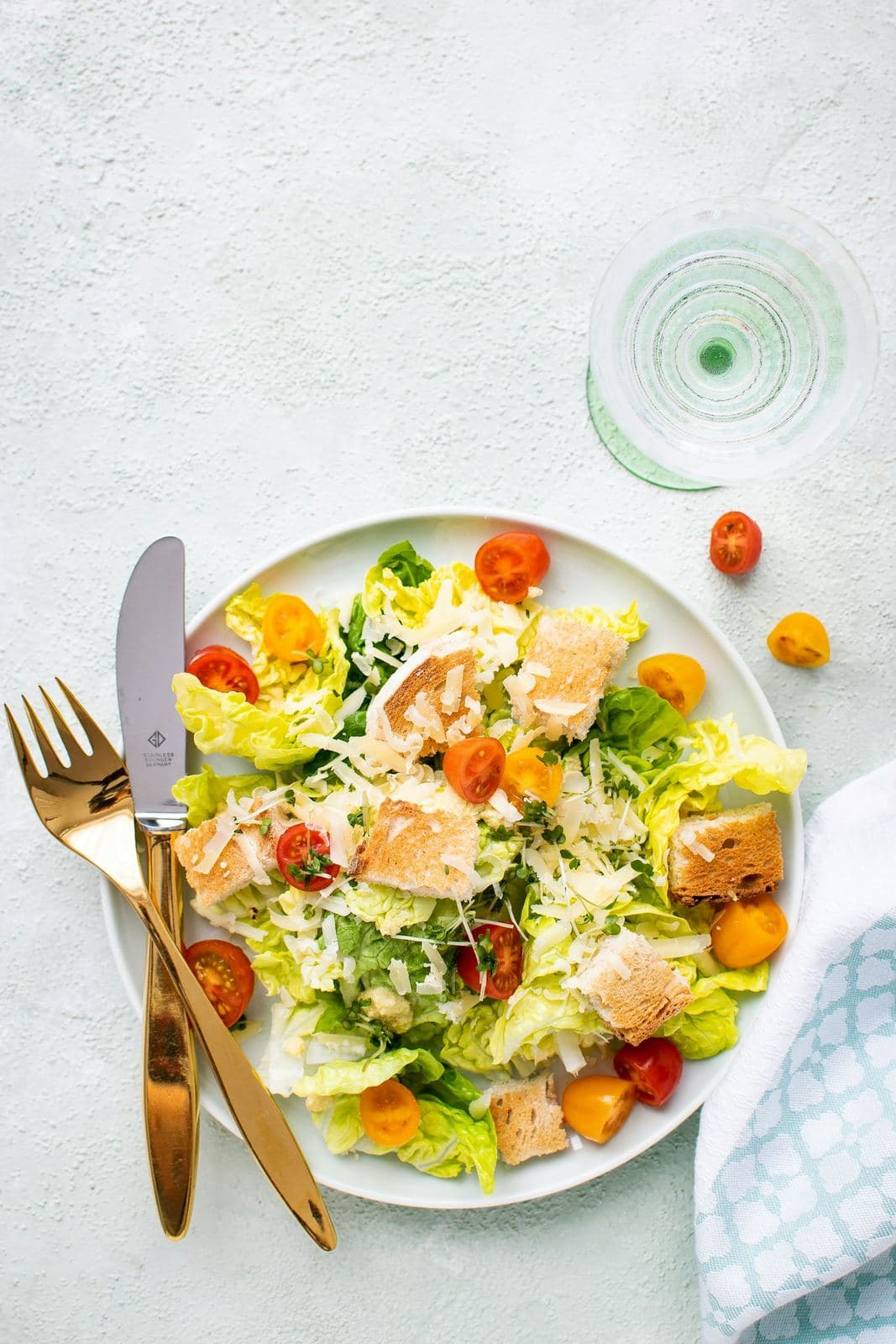 Ensalada en plato blanco con cubiertos